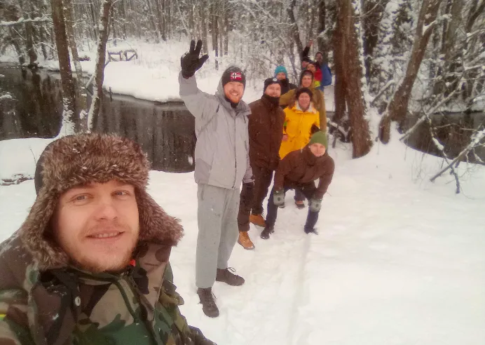 Grupė žygiuoja mišku į kalvą